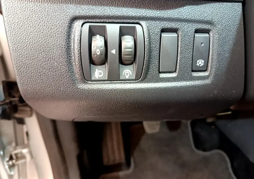 Gros plan sur les commandes de réglage des phares et fonction arrêt automatique du moteur de la Renault Clio Business TCe 90 2019.