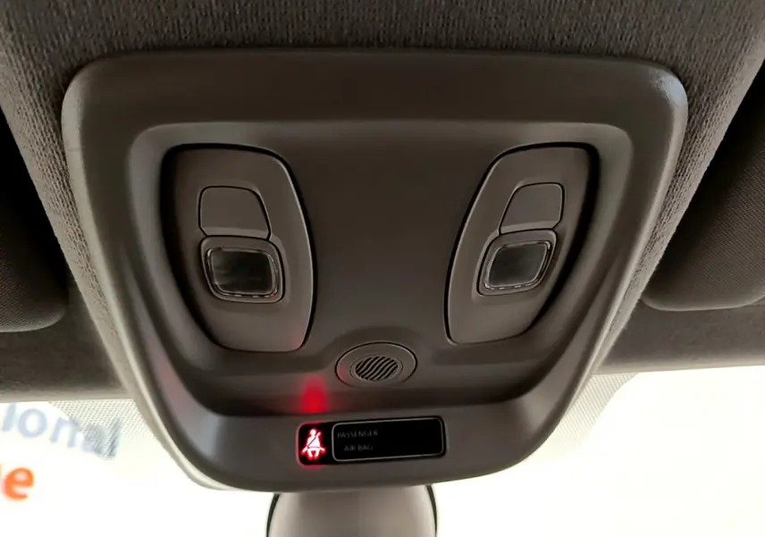 Gros plan sur la console de plafonnier gris clair de la Renault Clio Business TCe 90 avec témoin airbag passager allumé.
