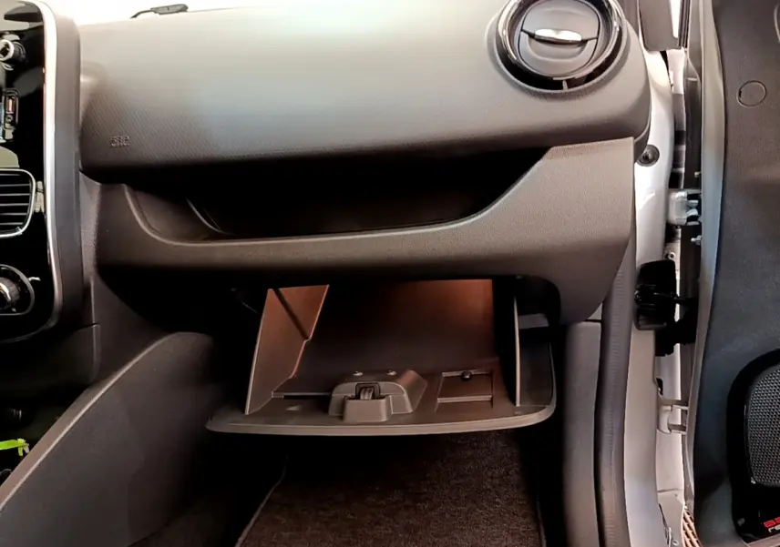 Gros plan sur la boîte à gants ouverte côté passager dans l'habitacle noir de la Renault Clio Business TCe 90 2019.