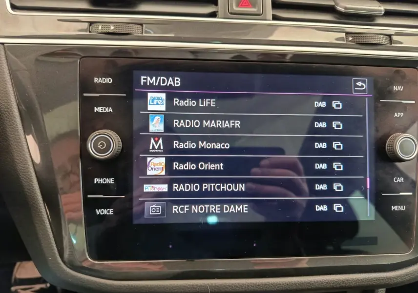 Écran tactile central du Volkswagen Tiguan 2.0 TDI 150 DSG7 Elegance affichant les stations radio FM/DAB.