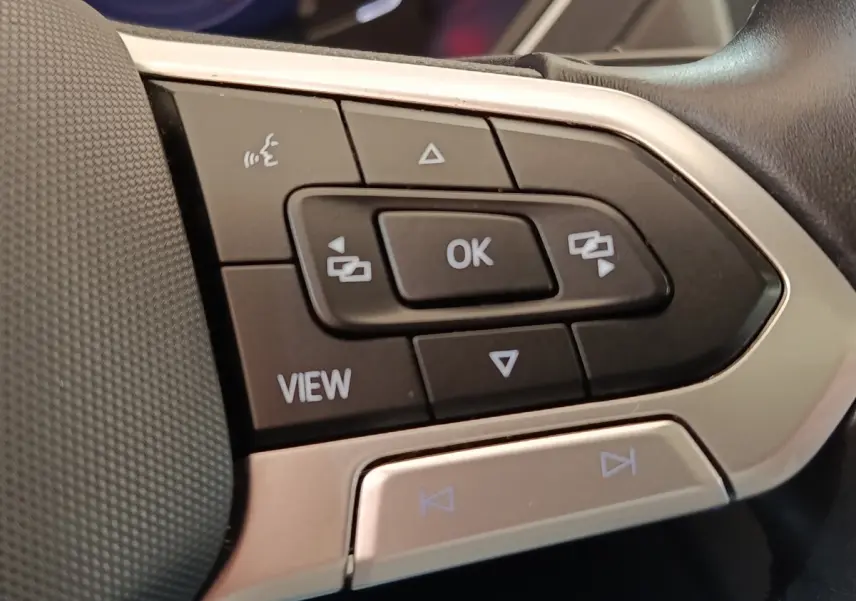 Gros plan sur les commandes multifonctions noires et argentées du volant du Volkswagen Tiguan 2.0 TDI 150 DSG7 Elegance.