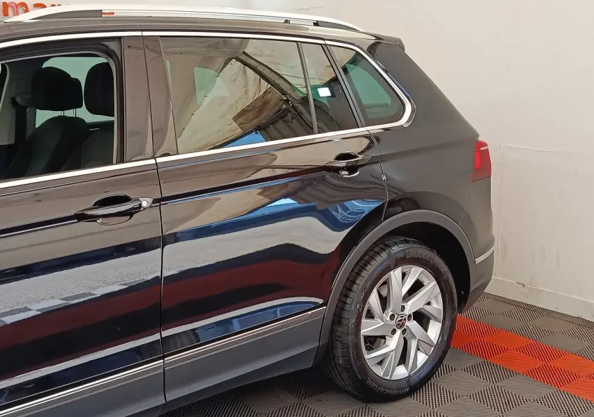 Vue latérale côté droit du Volkswagen Tiguan noir 2022, mettant en valeur les jantes alliage et les lignes de caisse chromées.