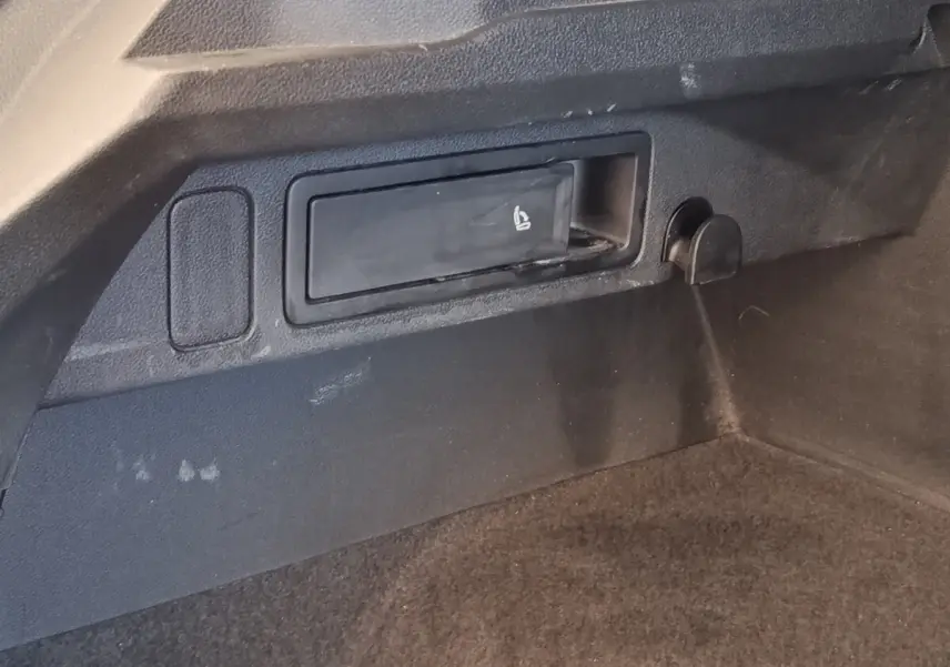 Détail du coffre noir du Volkswagen Tiguan 2.0 TDI 150 DSG7 Elegance avec levier de siège rabattable intégré.