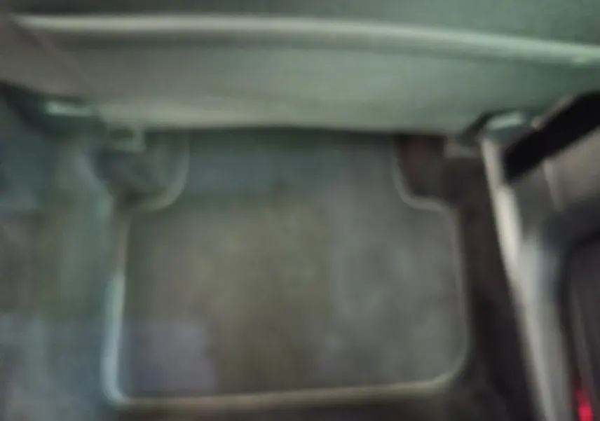 Vue intérieure du plancher côté conducteur du Volkswagen Tiguan noir 2022 avec tapis de sol gris foncé.