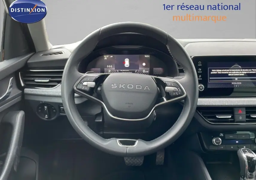 Vue intérieure centrée sur le volant SKODA du KAMIQ 2025, avec tableau de bord digital et écran tactile visible.