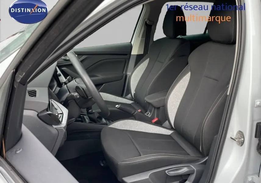 Vue intérieure côté conducteur du Skoda Kamiq blanc glacier 2025, sièges tissu bicolore noir et gris.