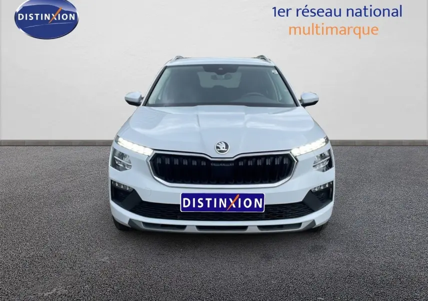 Vue avant du Skoda Kamiq blanc glacier 2025 avec calandre noire et feux LED allumés sur fond neutre.