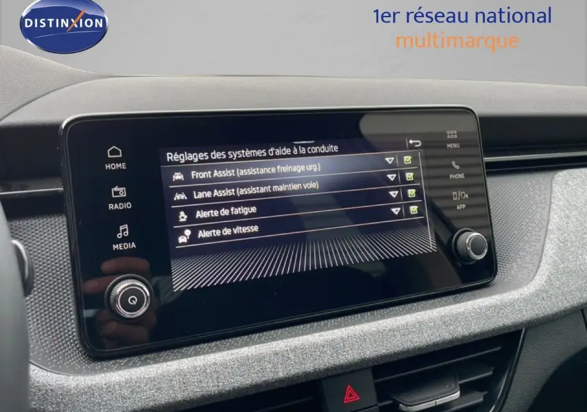 Écran tactile du tableau de bord du Skoda Kamiq blanc glacier, affichant les réglages d’aides à la conduite.