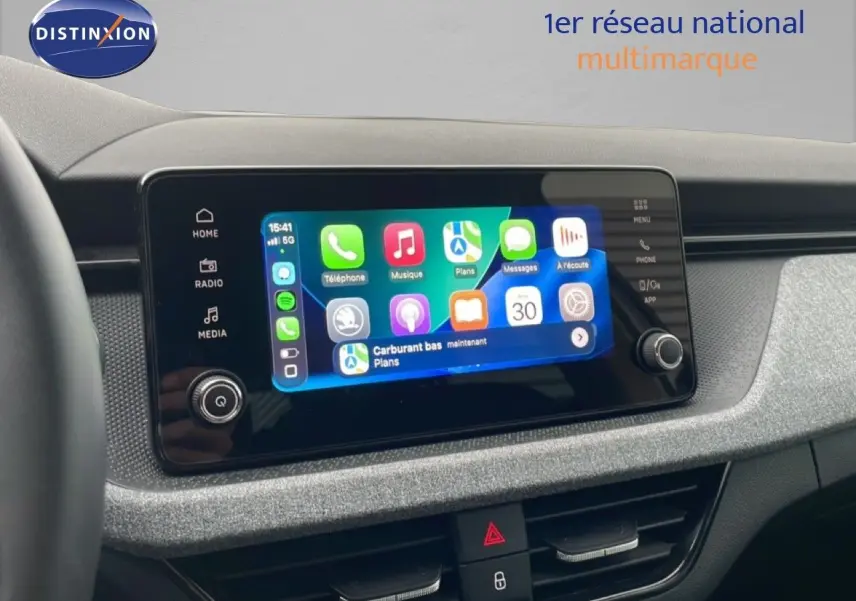 Écran tactile central du Skoda Kamiq blanc glacier 2025, affichant interface smartphone connectée, tableau de bord gris texturé.