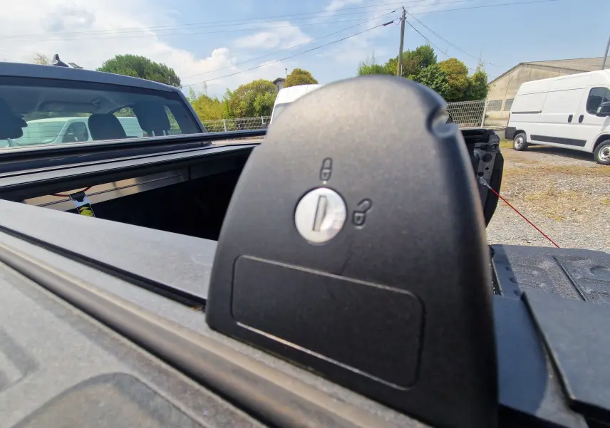 Gros plan sur le verrouillage du rideau de plateau rigide du Ford Ranger Super Cabine gris carbone, vue arrière ouverte.