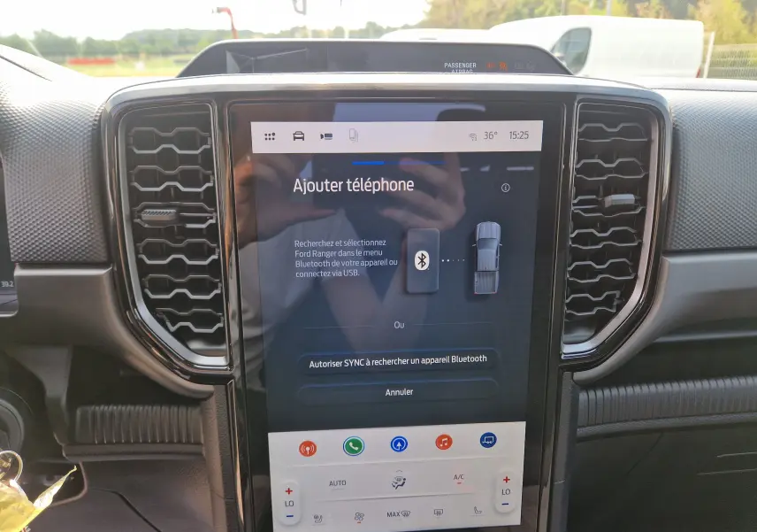 Vue intérieure centrée sur l'écran tactile 12,4'' du Ford Ranger Super Cabine gris carbone avec commandes climatisation visibles.