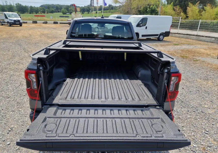 Vue arrière du Ford Ranger Super Cabine gris carbone avec plateau ouvert et rideau rigide coulissant visible.