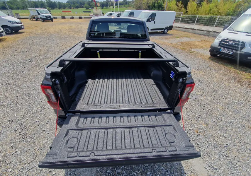 Vue arrière du Ford Ranger Super Cabine gris carbone avec plateau ouvert, rideau rigide coulissant et protection renforcée visible.