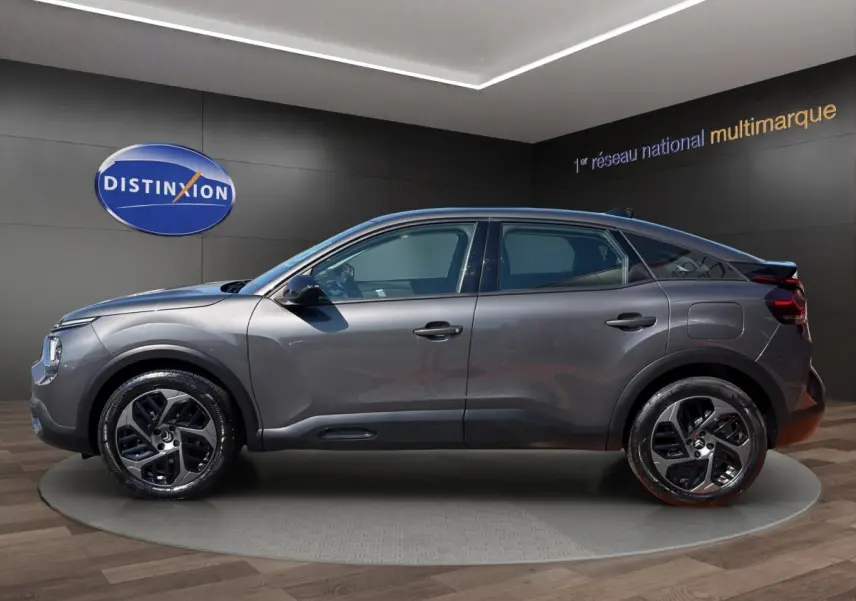 Profil droit d'une Citroën C4 gris foncé 2023 avec jantes noires et détails noirs contrastants.