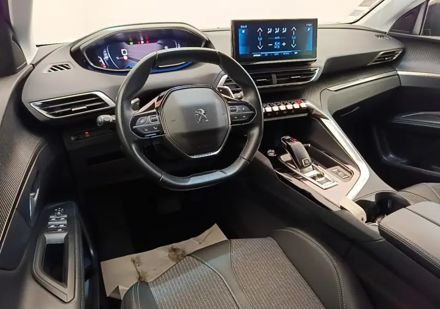 Vue intérieure avant du Peugeot 3008 noir 2022, volant cuir multifonctions et écran tactile central lumineux.