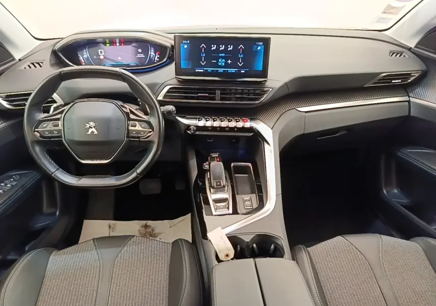 Vue intérieure avant du Peugeot 3008 noir 2022, volant cuir multifonctions et écran tactile central lumineux.