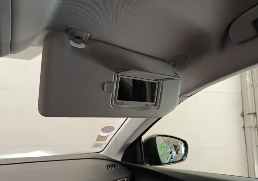 Vue intérieure côté passager du pare-soleil gris avec miroir intégré et rétroviseur extérieur noir du Peugeot 3008.