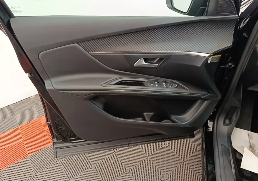 Intérieur porte avant gauche noire du Peugeot 3008 2022 avec commandes vitres et insert carbone.