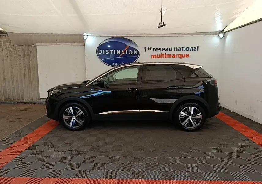 Profil côté gauche d’un Peugeot 3008 noir 2022 dans un garage avec sol gris et bandes rouges.