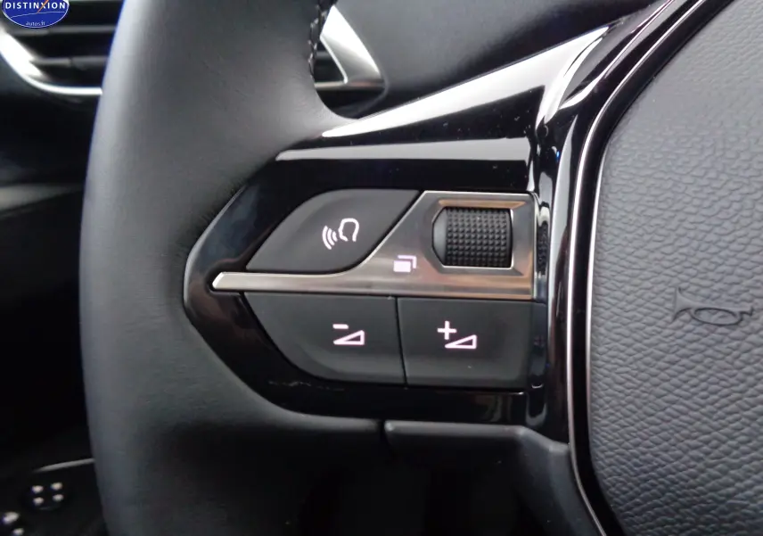 Gros plan sur les commandes au volant gauche du Peugeot 3008 gris platinium, avec boutons de volume et appel mains libres.