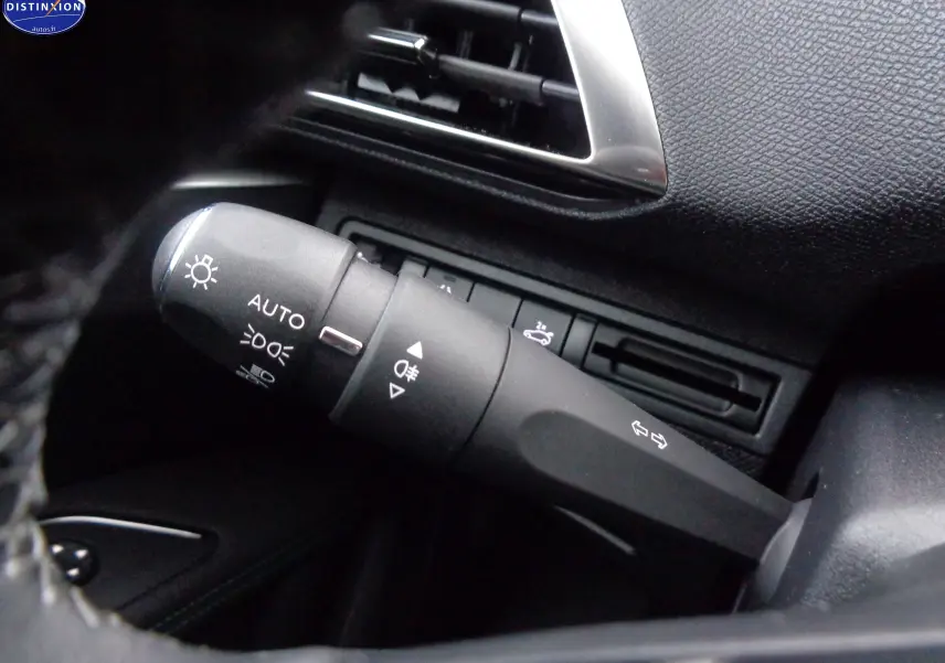 Gros plan sur la commande des feux et clignotants du Peugeot 3008 gris platinium, intérieur noir texturé.