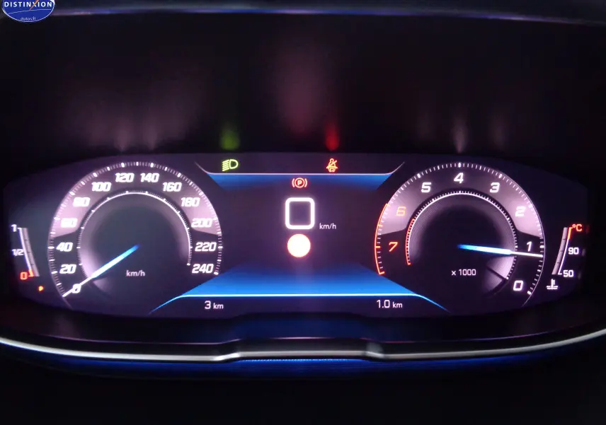 Tableau de bord numérique du Peugeot 3008 gris platinium, affichant vitesse à 0 km/h et compte-tours allumé.