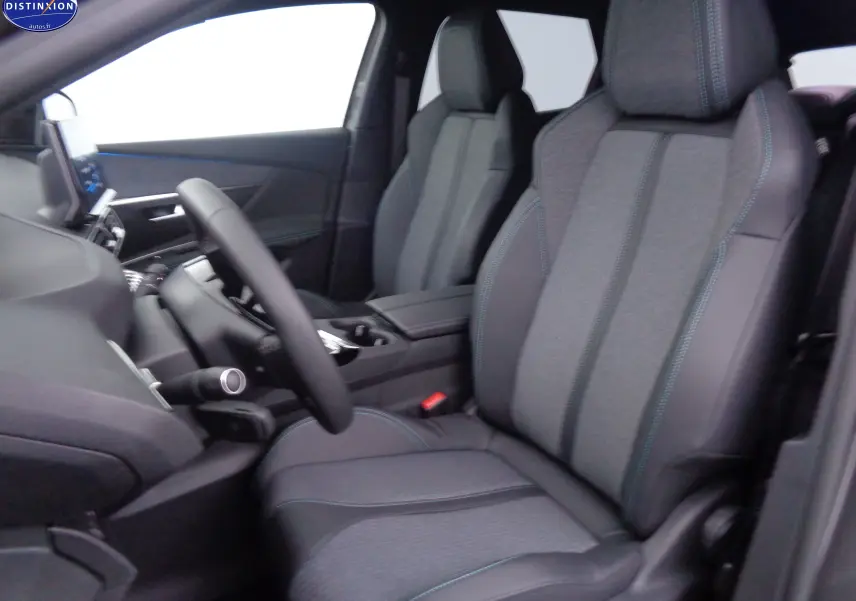 Vue intérieure côté conducteur du Peugeot 3008 2023, sièges en tissu gris et cuir noir avec surpiqûres bleues.