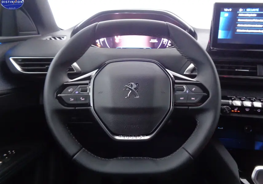 Vue rapprochée du volant cuir noir du Peugeot 3008 2023 avec commandes intégrées et tableau de bord digital.