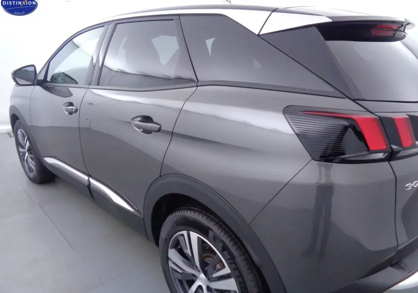 Vue 3/4 arrière droit d'un Peugeot 3008 gris platinium métal avec feux arrière à effet griffes et jantes alliage biton.