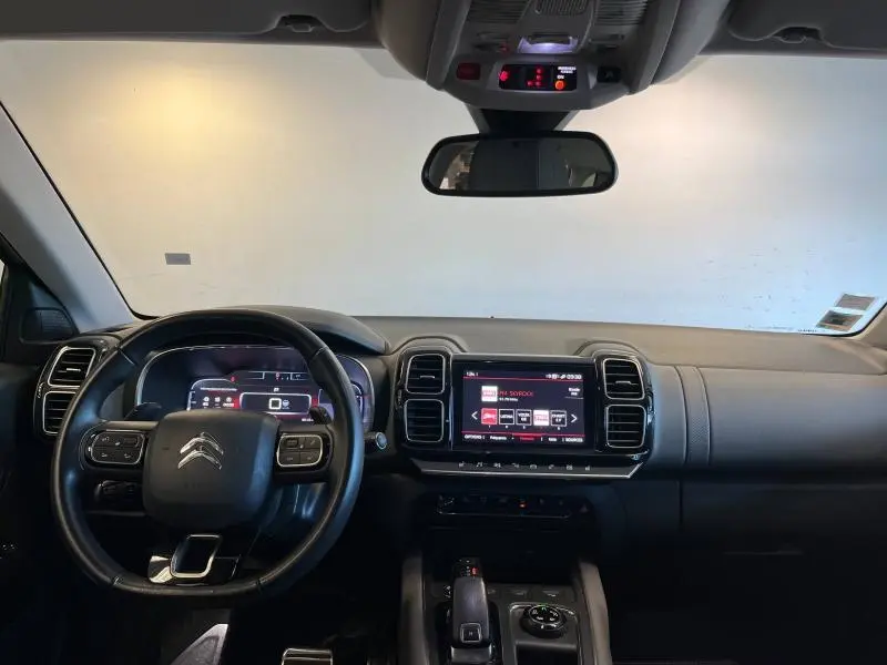 Intérieur noir du Citroën C5 Aircross 2020 vu de face, avec tableau de bord numérique et écran tactile central allumé.