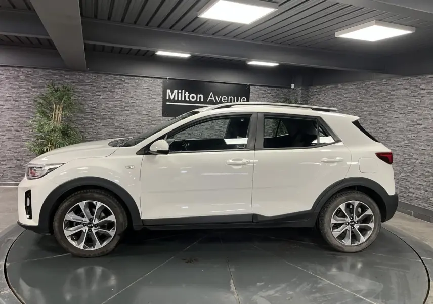 Profil côté gauche du Kia Stonic blanc 2019 avec jantes alliage 17 pouces et protections noires sur passages de roues.