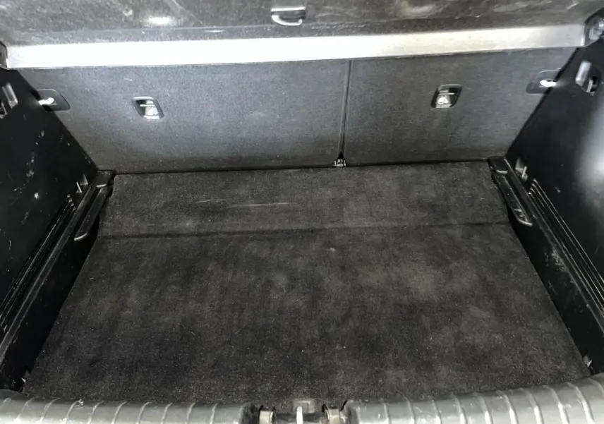 Coffre spacieux et propre du Kia Stonic blanc 2019, avec double plancher et revêtement noir.