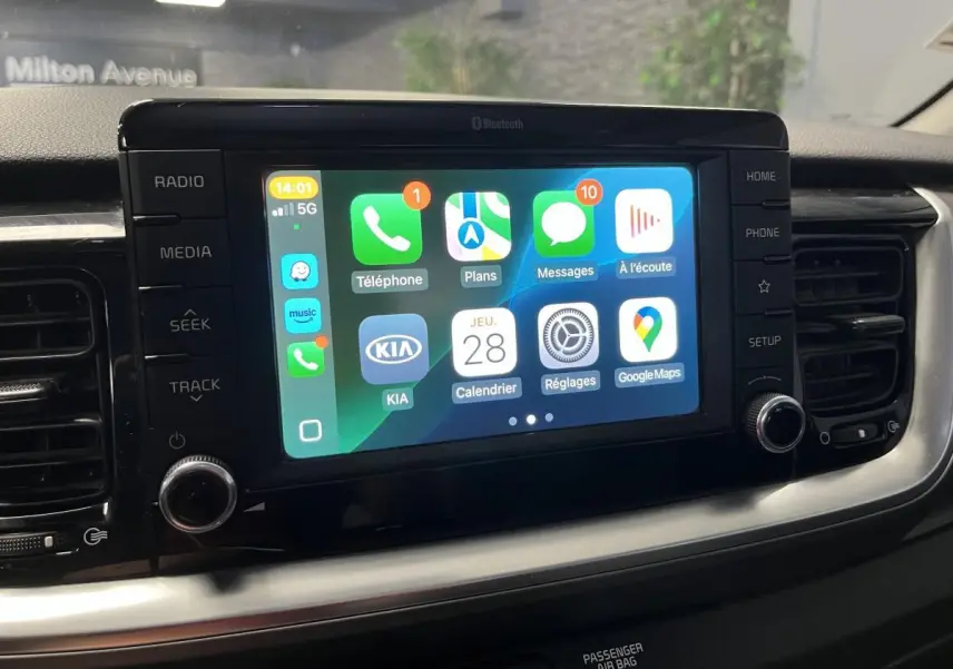 Écran tactile central 7 pouces du Kia Stonic 2019 affichant Apple CarPlay avec commandes autour en finition noire.