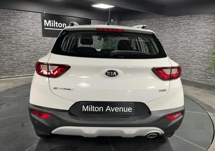 Vue arrière du KIA STONIC blanc de 2019 avec feux rouges et pare-chocs noir contrastant en intérieur showroom.
