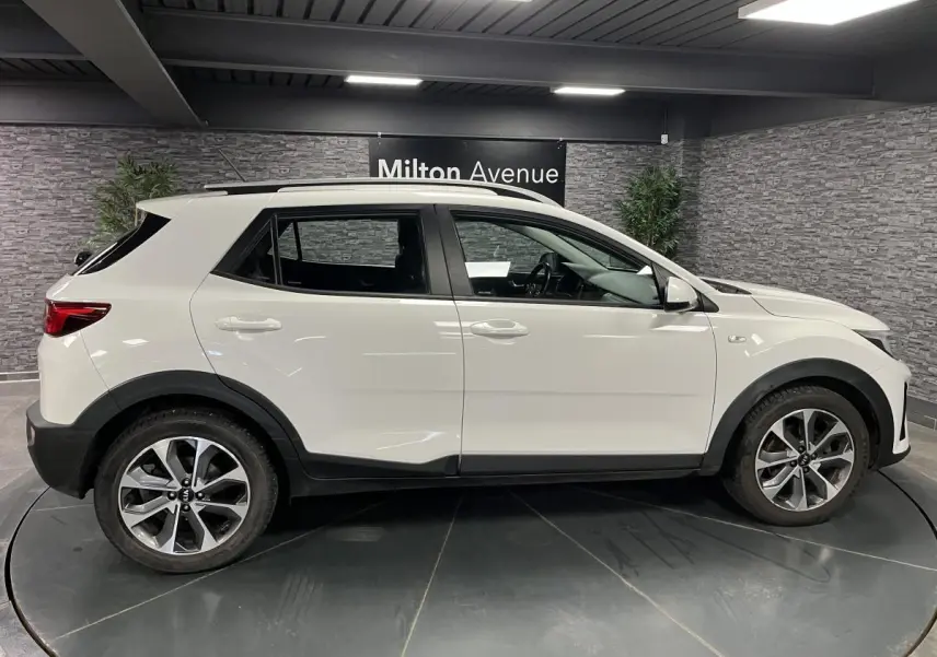 Profil droit du KIA STONIC blanc 2019 avec jantes alliage 17 pouces et protections noires sur les passages de roues.