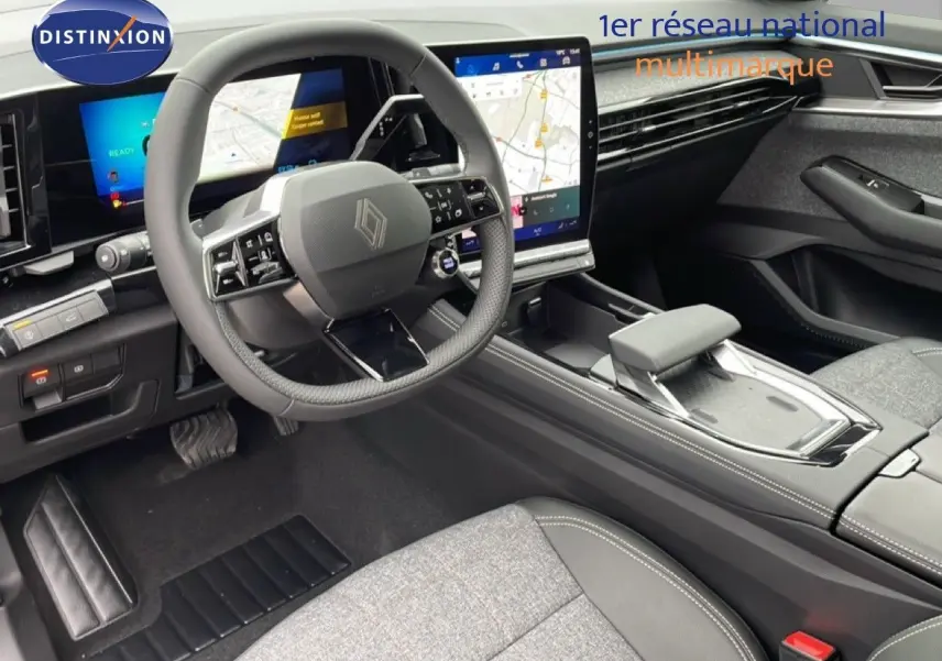 Vue intérieure côté conducteur du Renault Espace 2025, tableau de bord numérique et sellerie tissu gris avec inserts cuir noir.