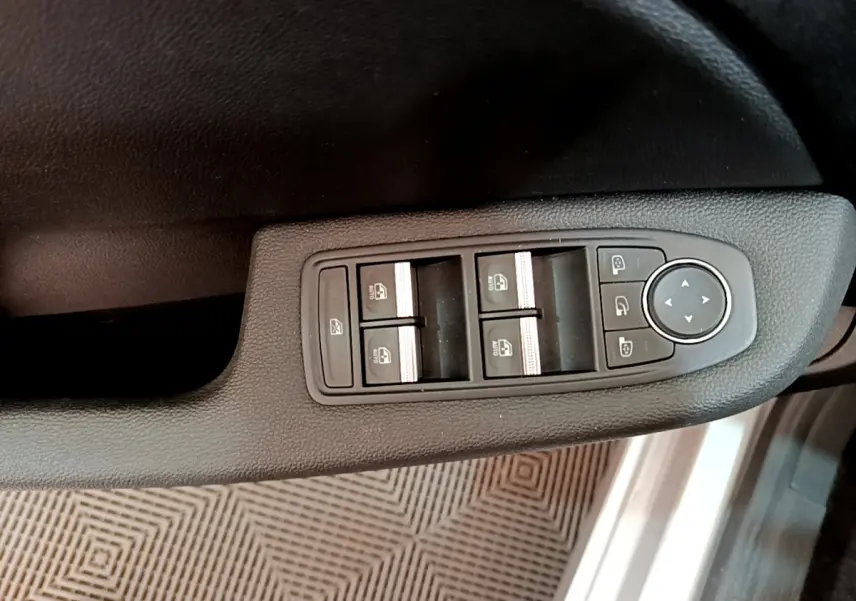 Panneau de commandes des vitres et rétroviseurs côté conducteur de la Renault Clio Business gris clair, vue intérieure rapprochée.