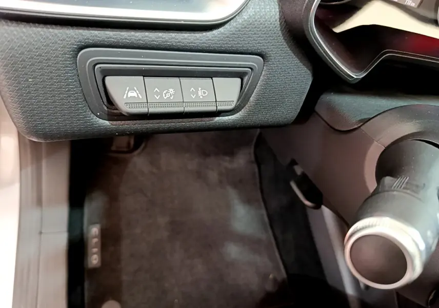 Vue rapprochée du tableau de bord côté gauche de la Renault Clio Business TCe 100, avec commandes d'assistance et volant partiel.