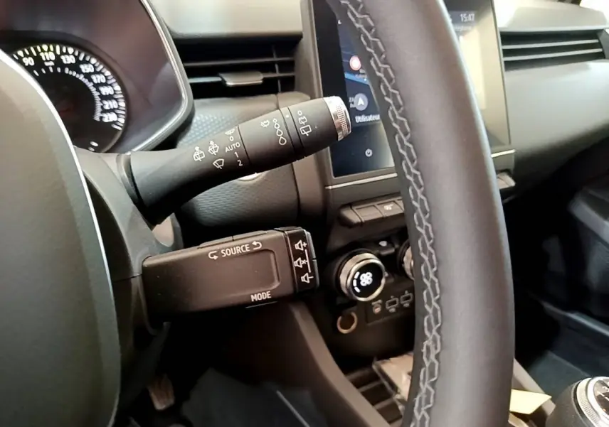 Vue rapprochée du volant et du tableau de bord de la Renault Clio Business TCe 100, avec commandes au volant et écran tactile.