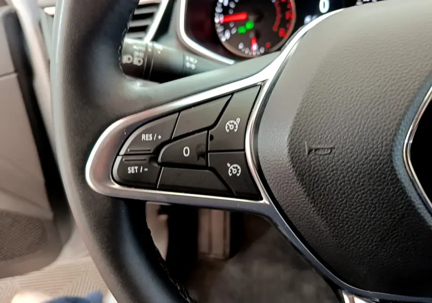 Gros plan sur les commandes du régulateur de vitesse au volant en cuir noir de la Renault Clio Business TCe 100 2020.