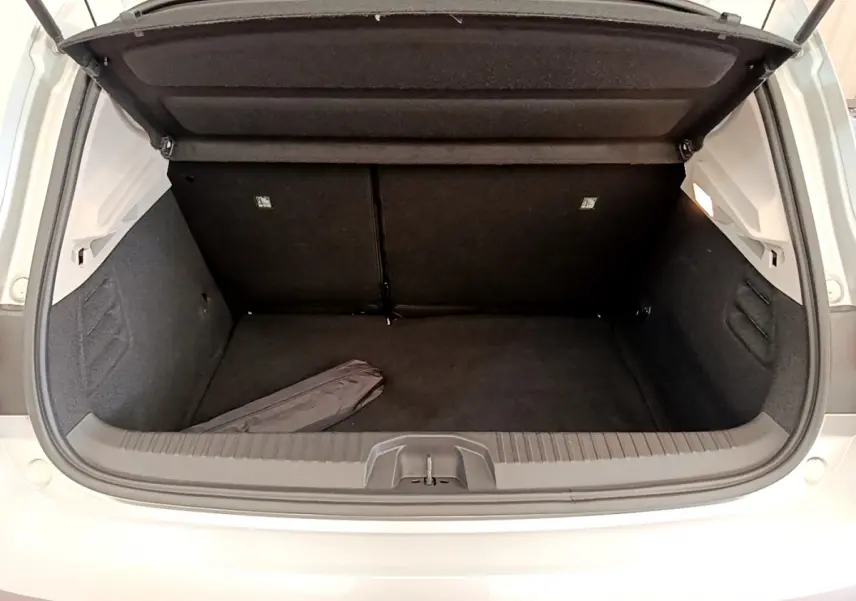 Coffre ouvert vu de l'arrière d'une Renault Clio Business TCe 100 gris clair, montrant un espace de chargement propre et spacieux.