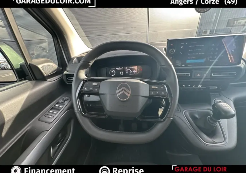 Vue intérieure centrée sur le volant cuir multifonctions et le tableau de bord numérique du Citroën Berlingo gris clair 2024.