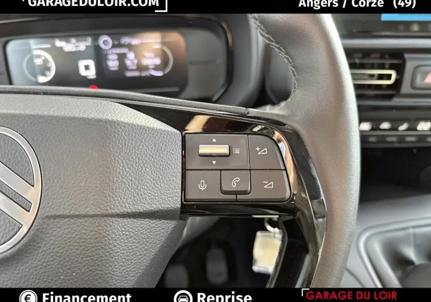 Gros plan sur le volant cuir multifonctions gris du Citroën Berlingo 2024 avec commandes vocales et téléphone.