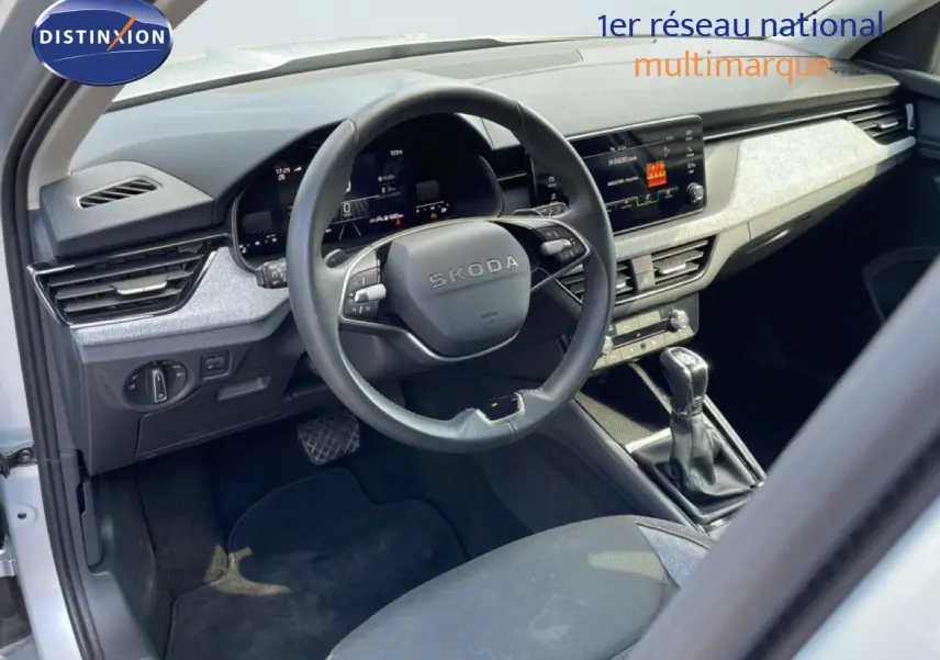 Vue intérieure côté conducteur du Skoda Kamiq gris argent, avec tableau de bord digital et volant multifonction.