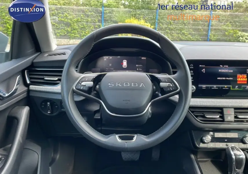 Vue intérieure centrée sur le volant cuir noir du Skoda Kamiq 2025 avec tableau de bord digital et écran multimédia.