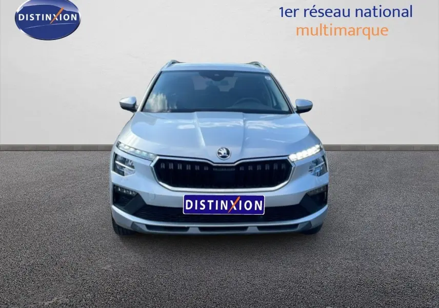 Vue avant d'un Skoda Kamiq gris argent métallisé 2025 avec calandre noire et feux LED allumés.