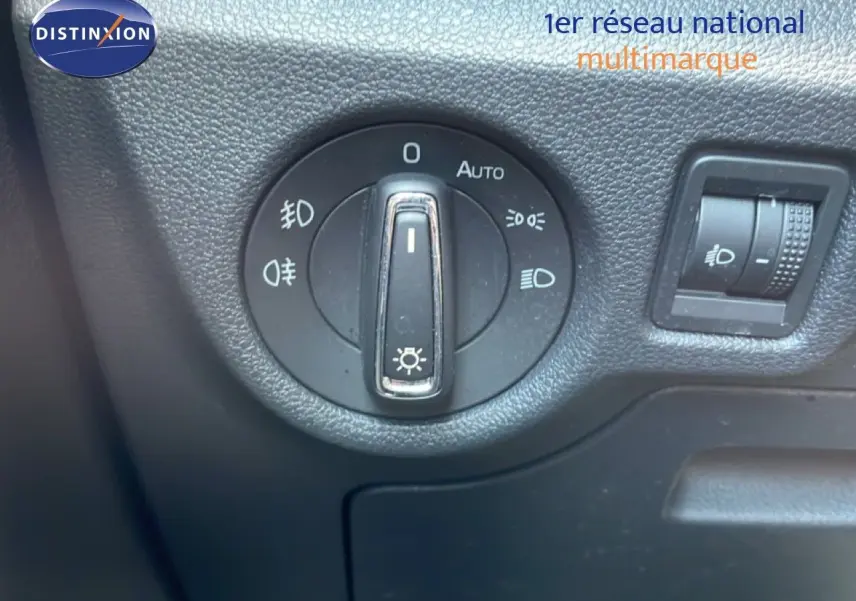 Gros plan sur le bouton de commande des phares du Skoda Kamiq gris argent, intérieur noir texturé.