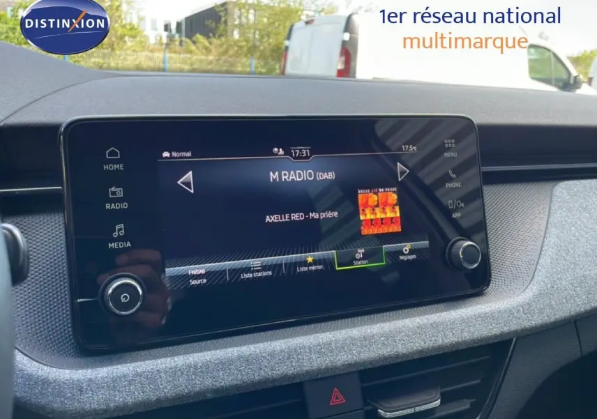 Écran tactile central de la Skoda Kamiq 2025 gris argent, affichant la radio numérique avec station et titre en cours.