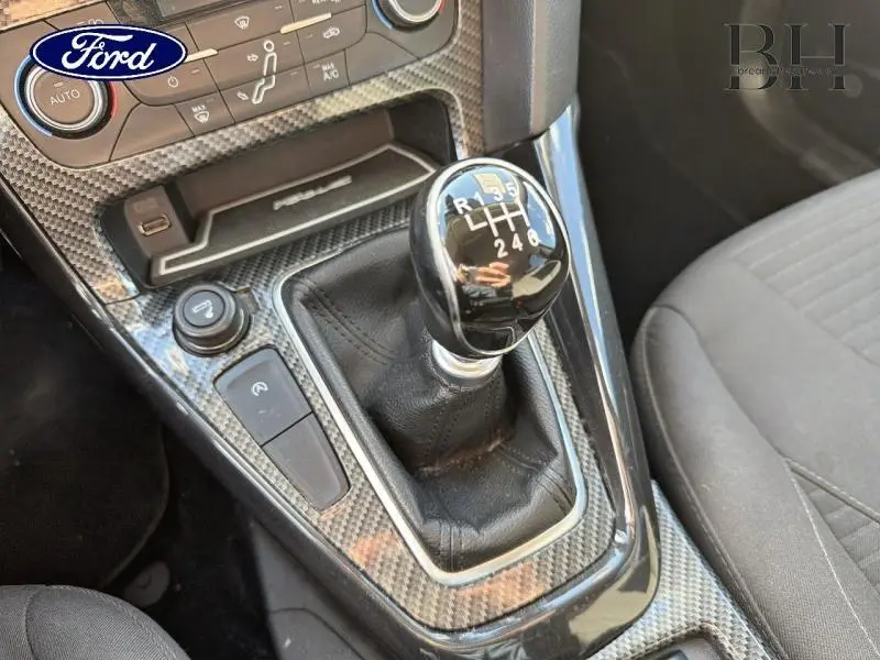 Gros plan sur le levier de vitesses manuel noir entouré d’un habillage effet carbone dans une Ford Focus Titanium 2016.