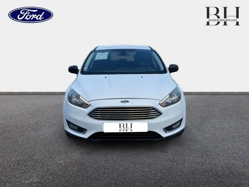 Ford Focus 1.0 EcoBoost blanc glacier vue de face, calandre chromée et phares halogènes visibles.